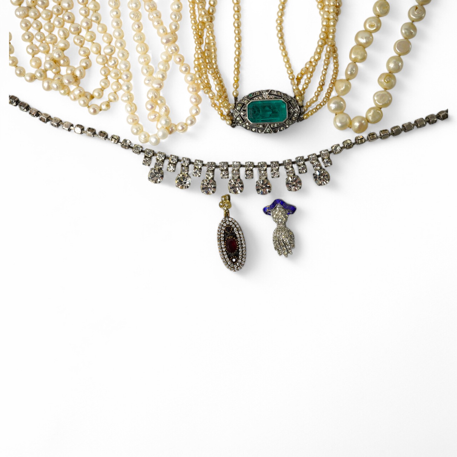 A collection of costume jewellery, comprising: a simulant pearl necklace with a green and colourless paste clasp; a fringe necklace set with circular-cut pastes; three strands of cultured pearls; a Royal Artillery cap ba